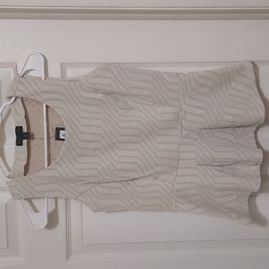 Short sleeved cream colored peplum top with woven detail